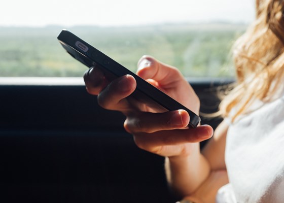 A woman holding a Smartphone in her hand while on public transport
