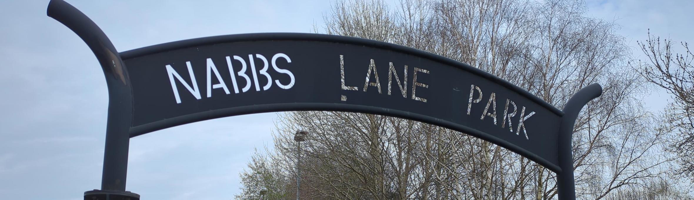 A metal archway that spells out Nabbs Lane Park 