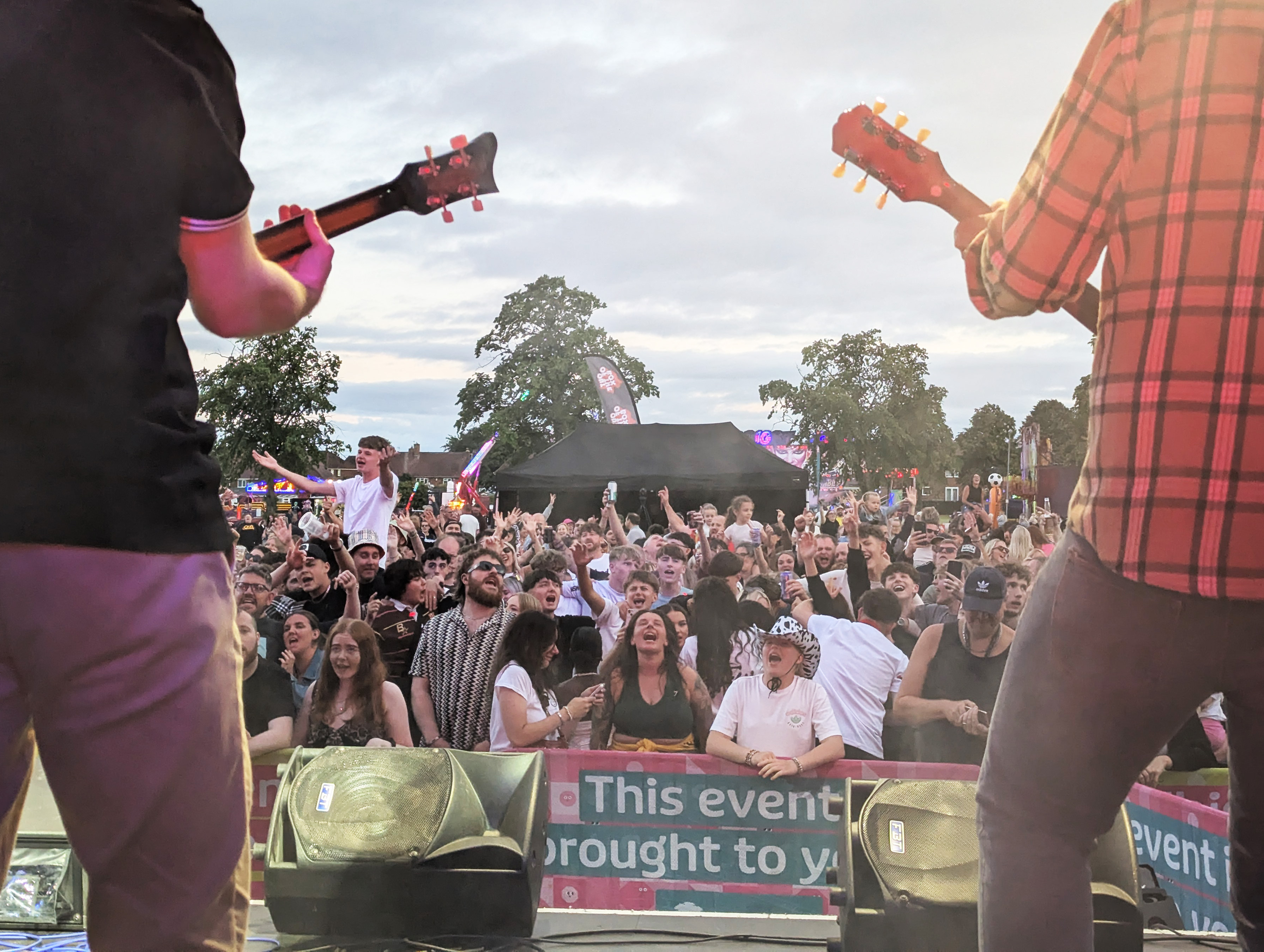 a crowd of people singing along in front of a stage 
