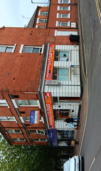 A shop with white walls and an orange sign that reads Hucknall Cloud