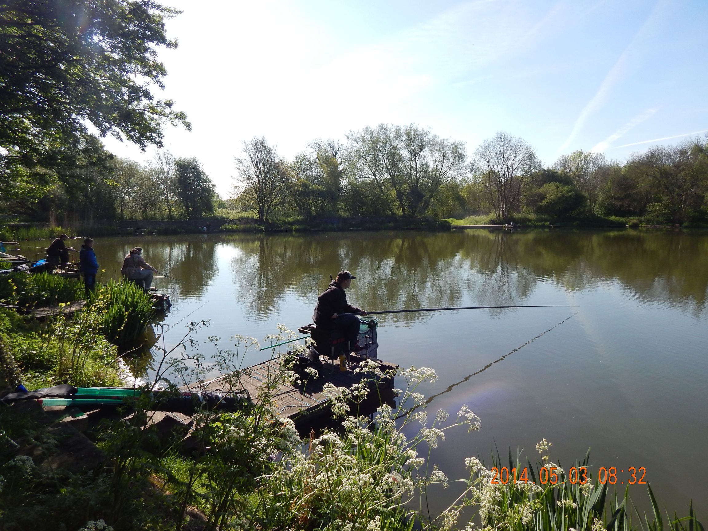 People along the edge of a lake fishing