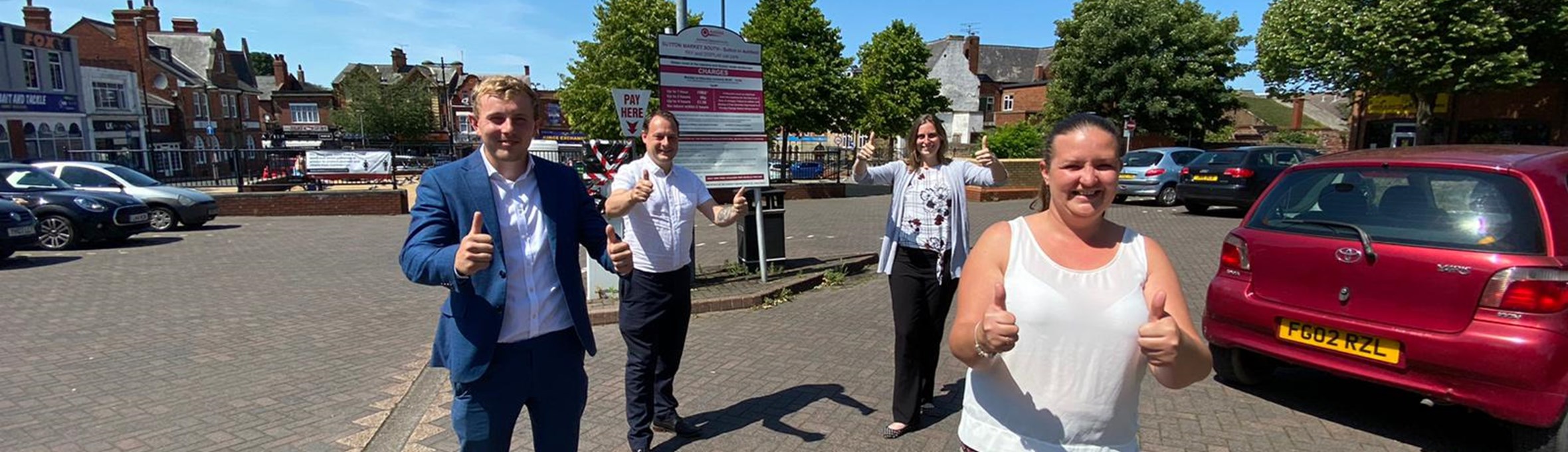 Councillors standing in a car park with thumbs up