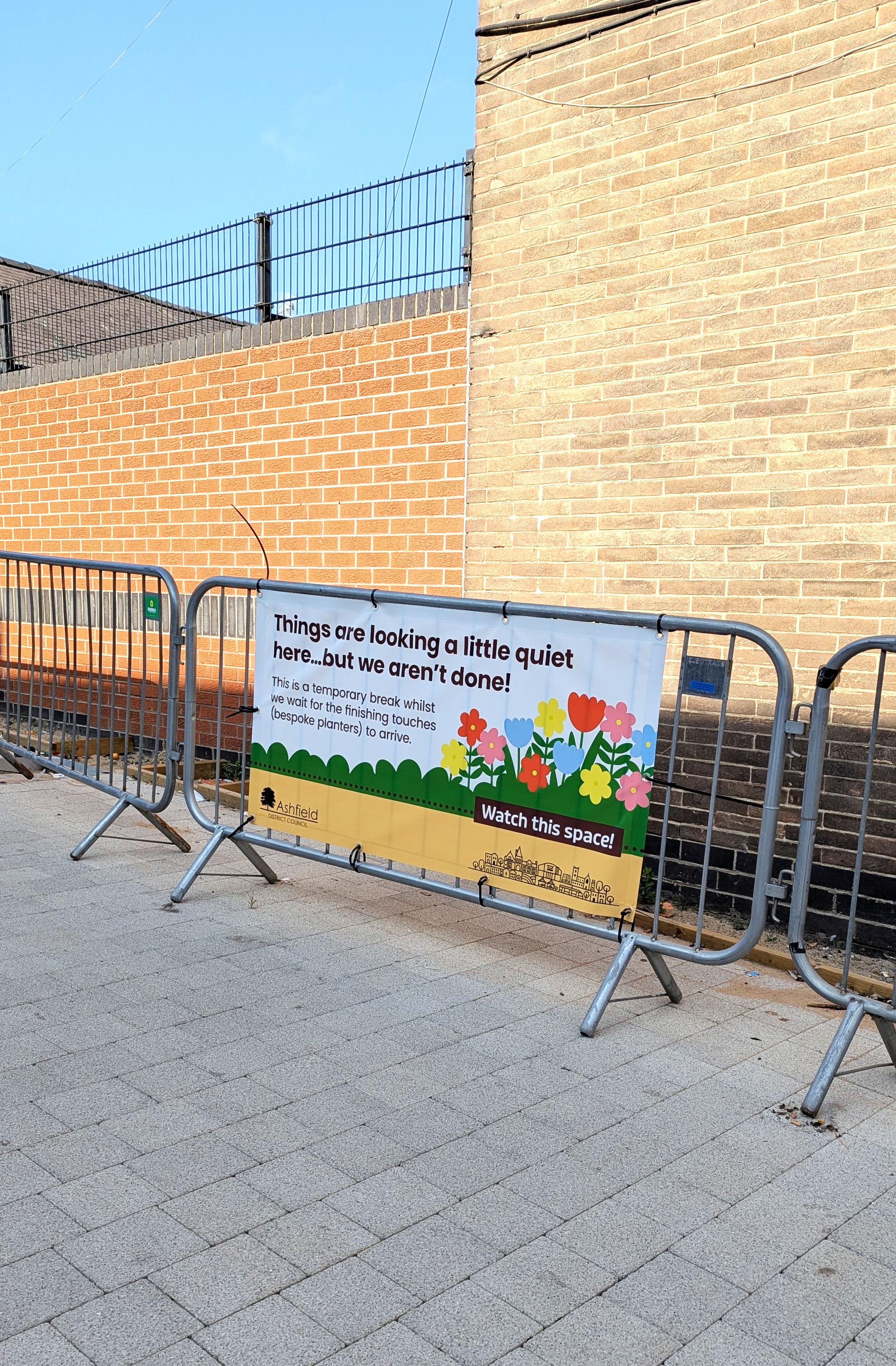 a banner on a small railing that reads things are looking a little quiet here but we aren't done 