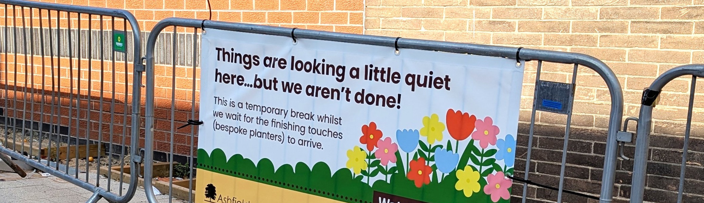 a banner on a small railing that reads things are looking a little quiet here but we aren't done 
