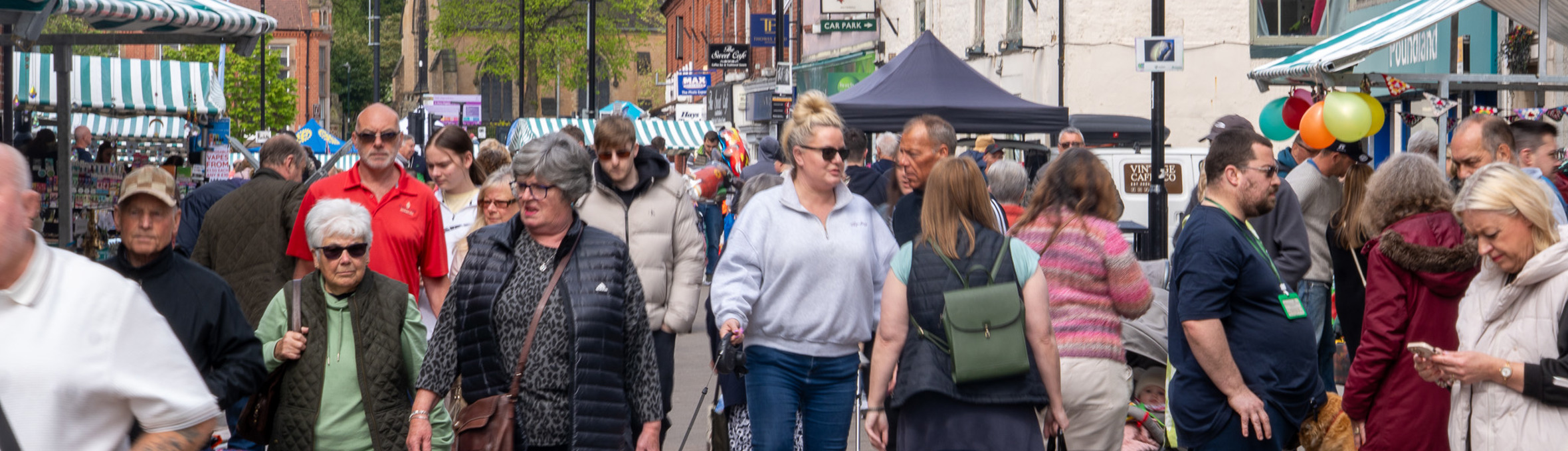 A crowd of people walking through and shopping at Hucknall High Street