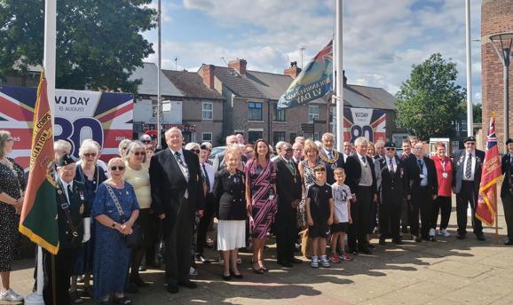 Civic guests and Ashfield councillors raise the VJ Day flag in Ashfield