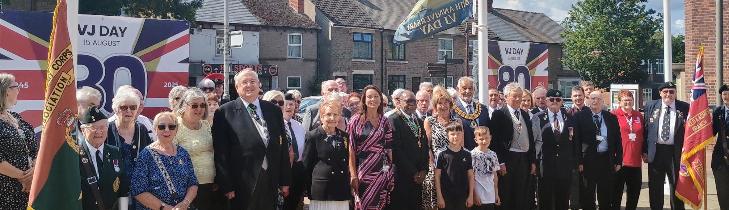 Civic guests and Ashfield councillors raise the VJ Day flag in Ashfield