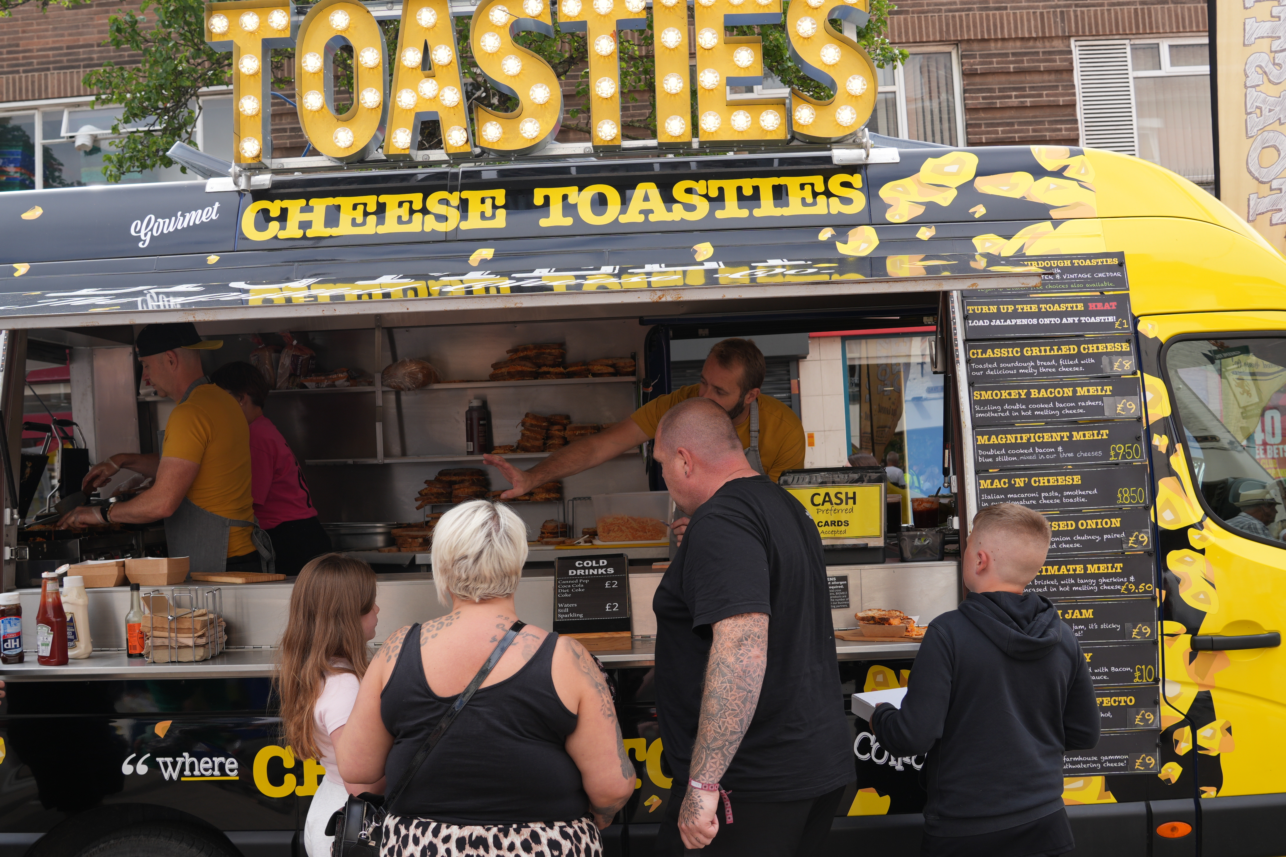 a family in front of a yellow van that says toasties 
