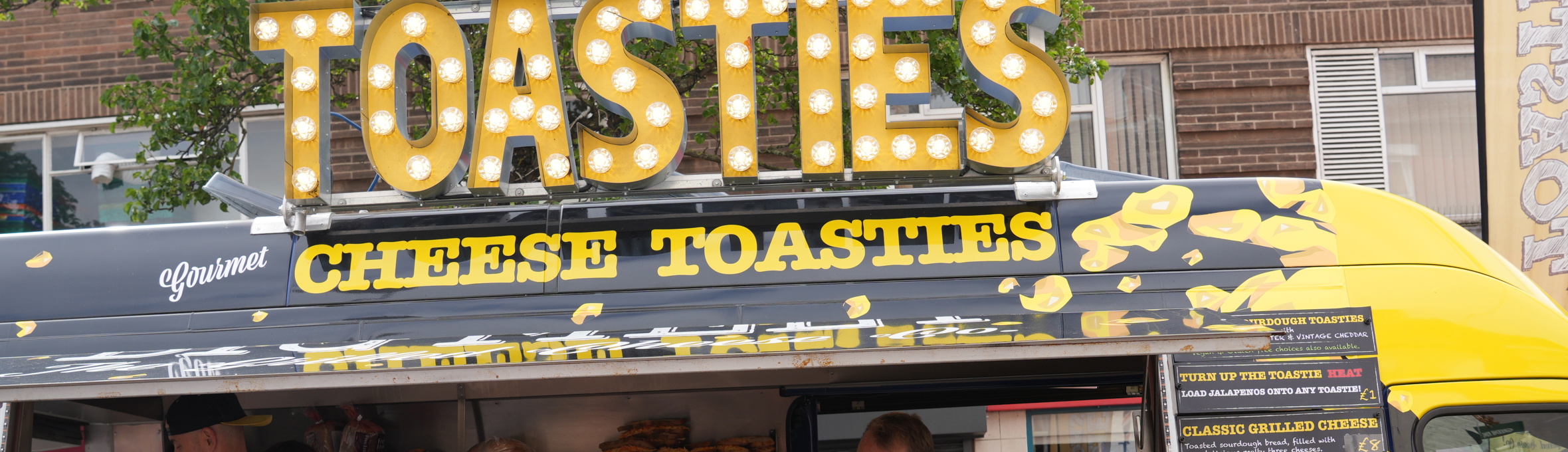 a family in front of a yellow van that says toasties 