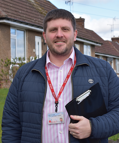 Man smiling at camera and wearing a Ashfield District Council lanyard and carrying a clipboard