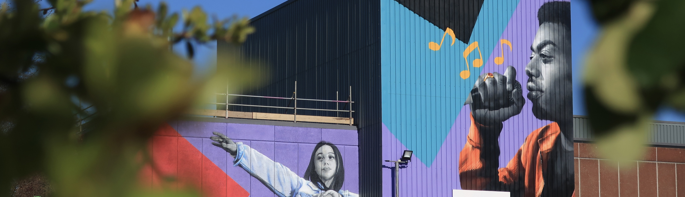 Two photo-realistic murals painted on the side of Cornerstone Theatre in Sutton 