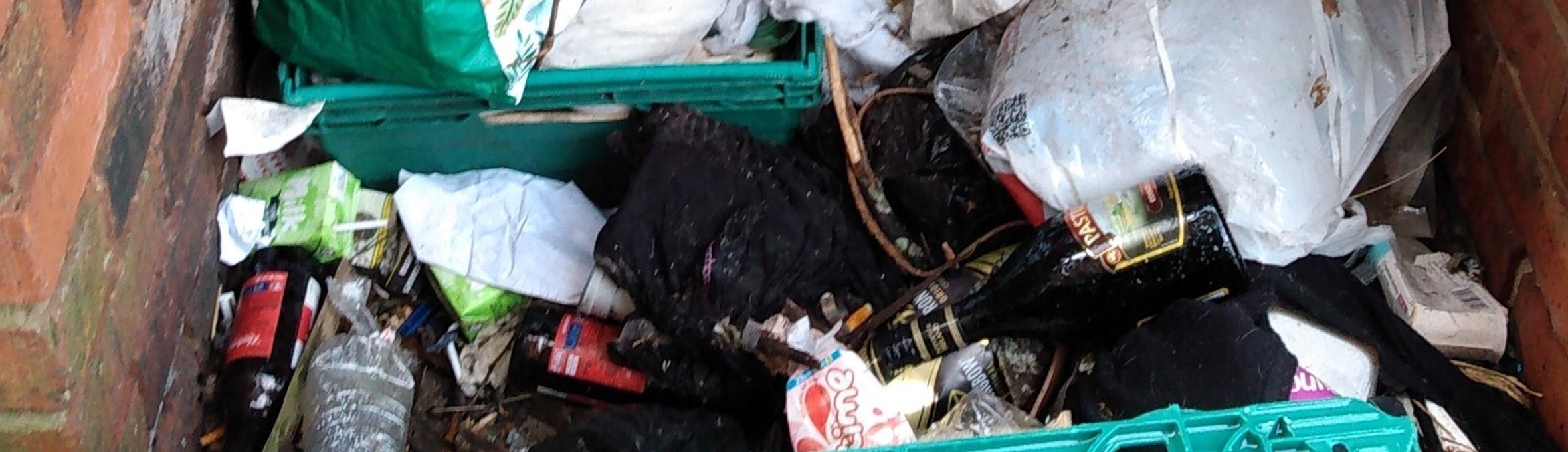 several bags of waste are pilled up in an outbuilding