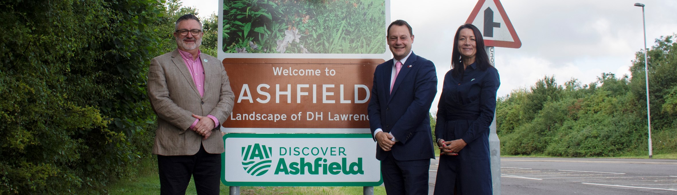 Martin Rigley, Cllr Jason Zadrozny, and Theresa Hodgkinson, CEO stand in front of Ashfield road sign