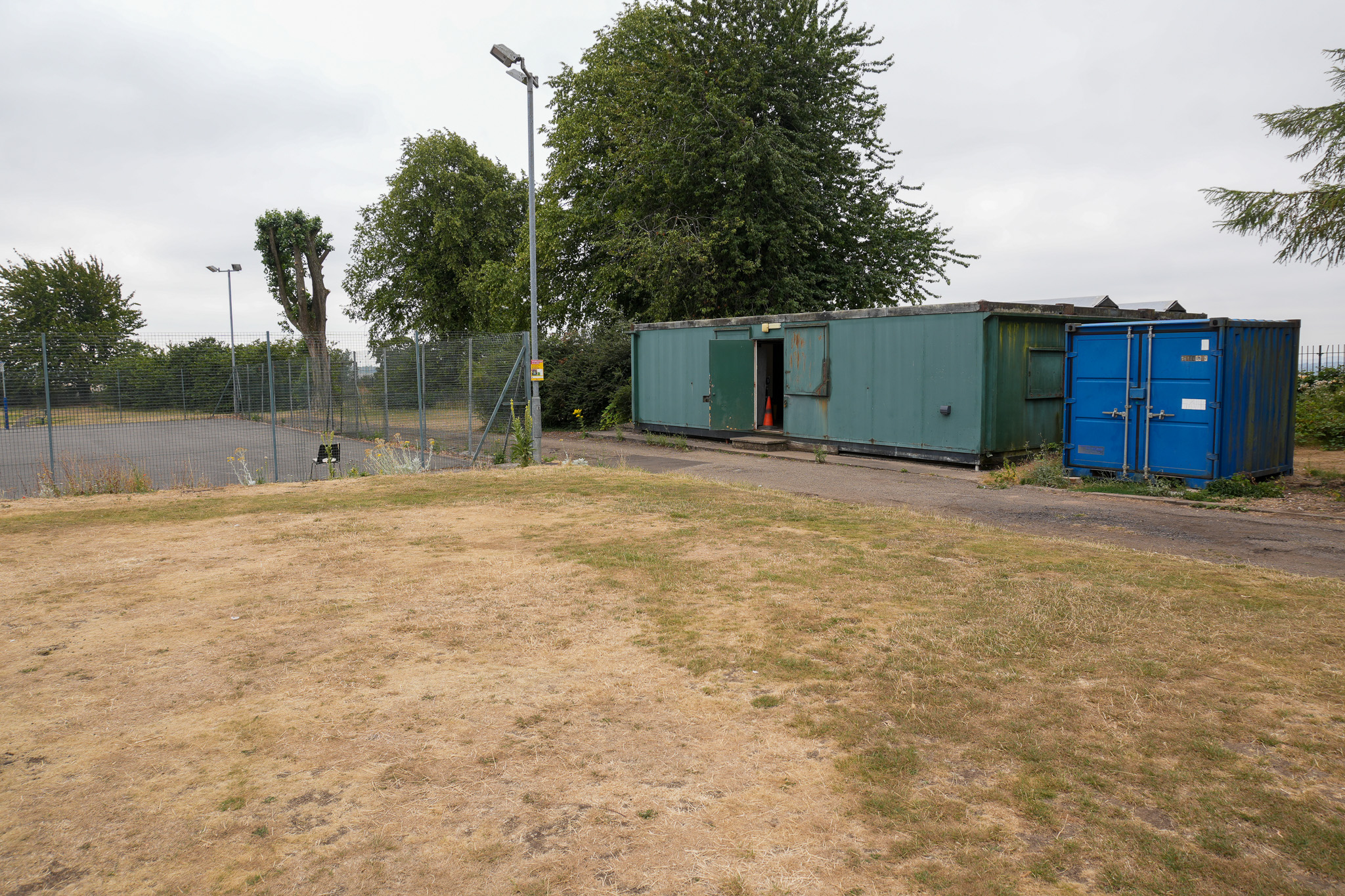 A netball court and a blue shipping container 