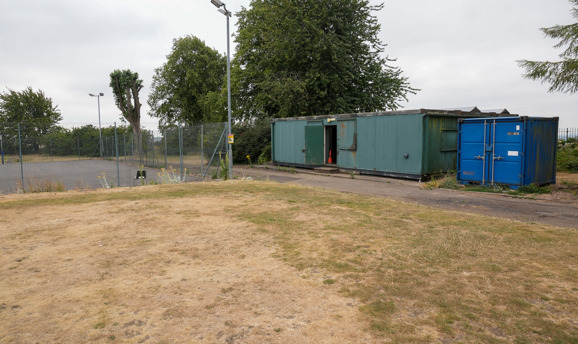 A netball court and a blue shipping container 