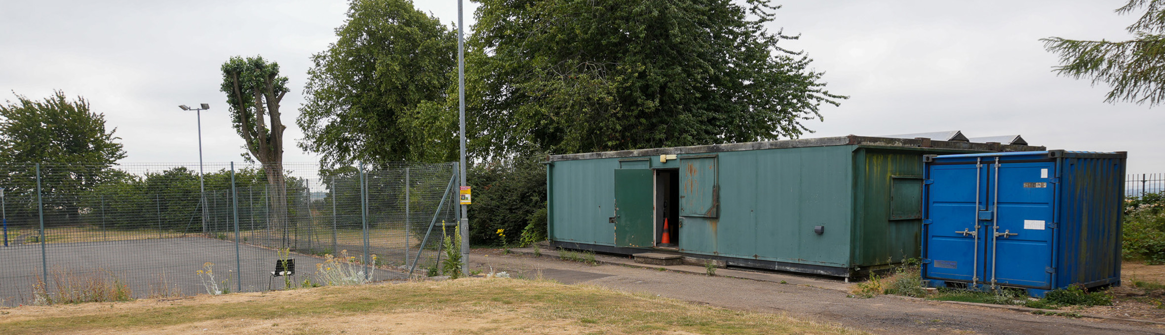 A netball court and a blue shipping container 