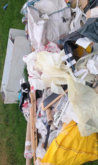 A large fly tip with black bags, builders bags and cupboards 