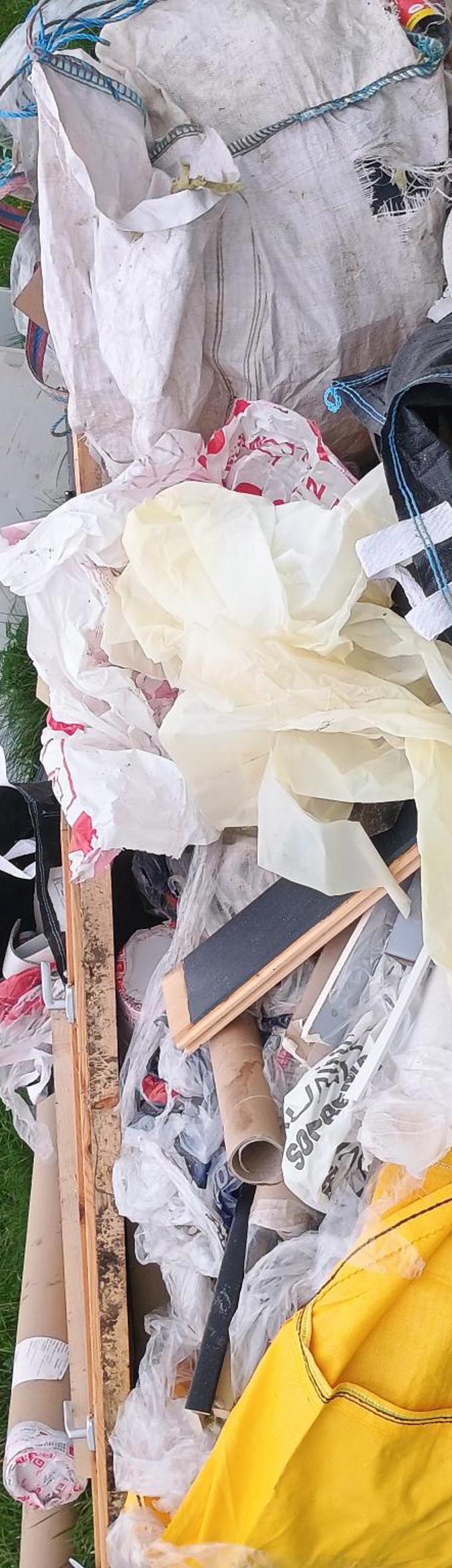 A large fly tip with black bags, builders bags and cupboards 