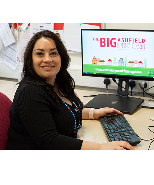 Woman sat in front of a computer monitor displaying logo for Big Ashfield Spring Clean