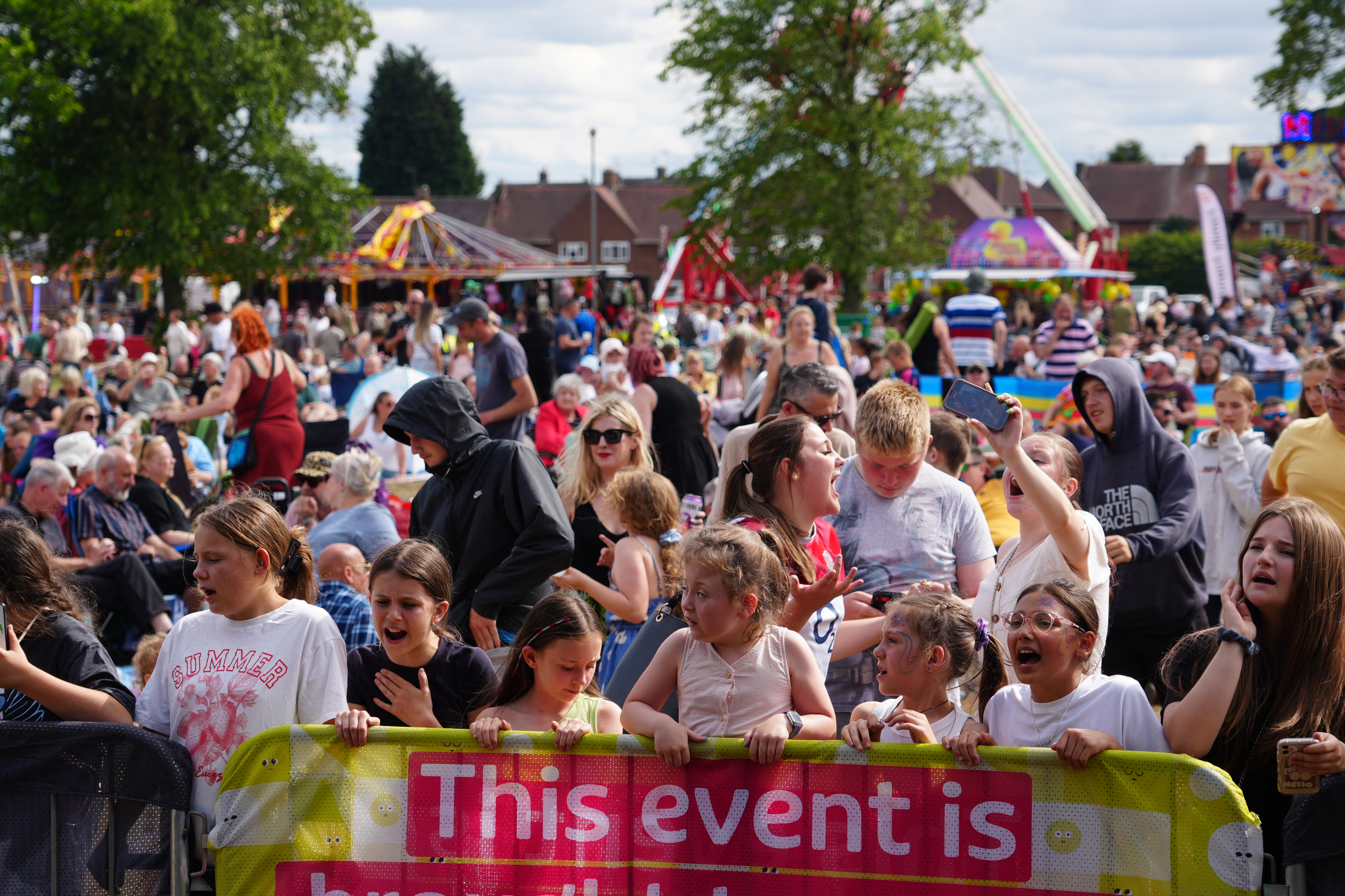 A large crowd of people are gathered in front of a stage 