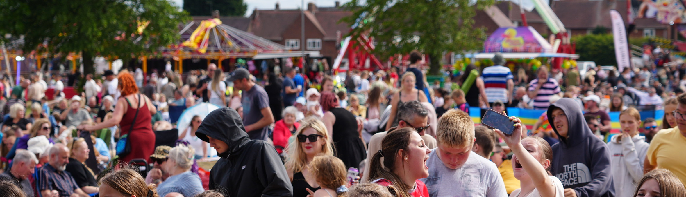 A large crowd of people are gathered in front of a stage 