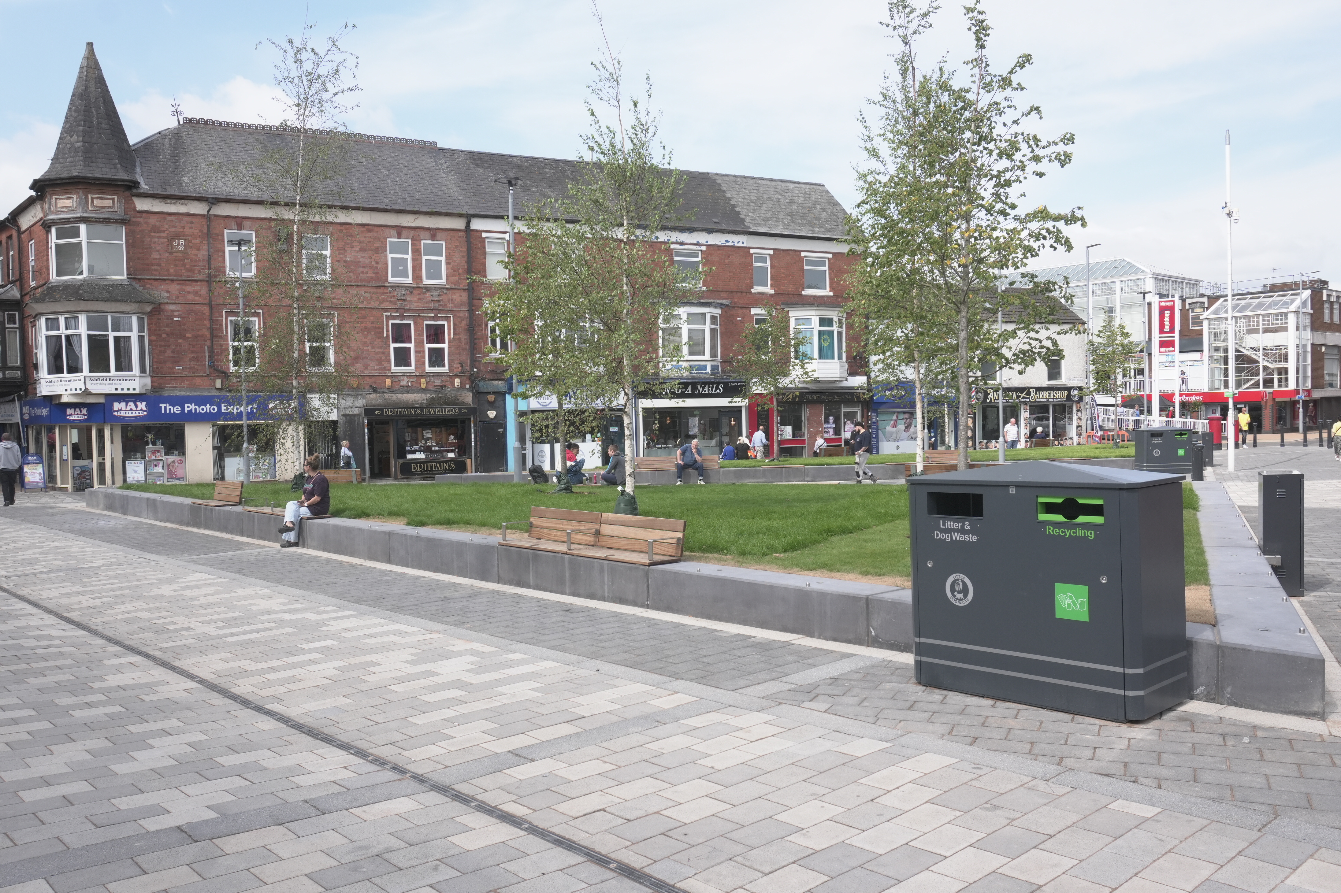 Portland square with grey paving, grass and trees  