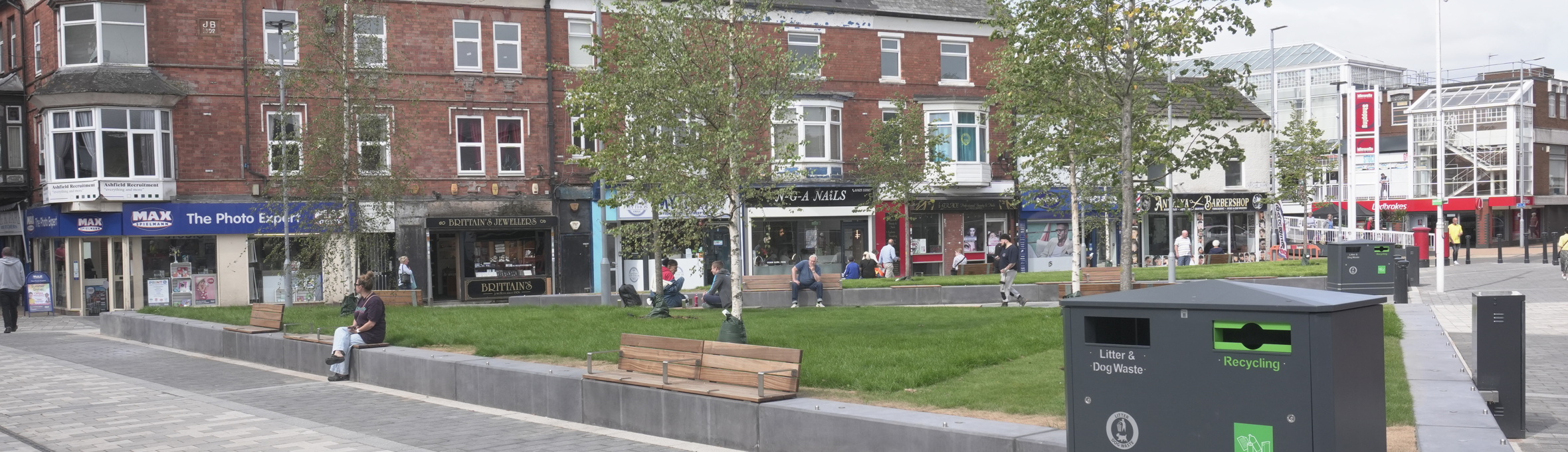 Portland square with grey paving, grass and trees  