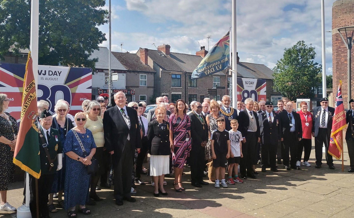 Civic guests and Ashfield councillors raise the VJ Day flag in Ashfield