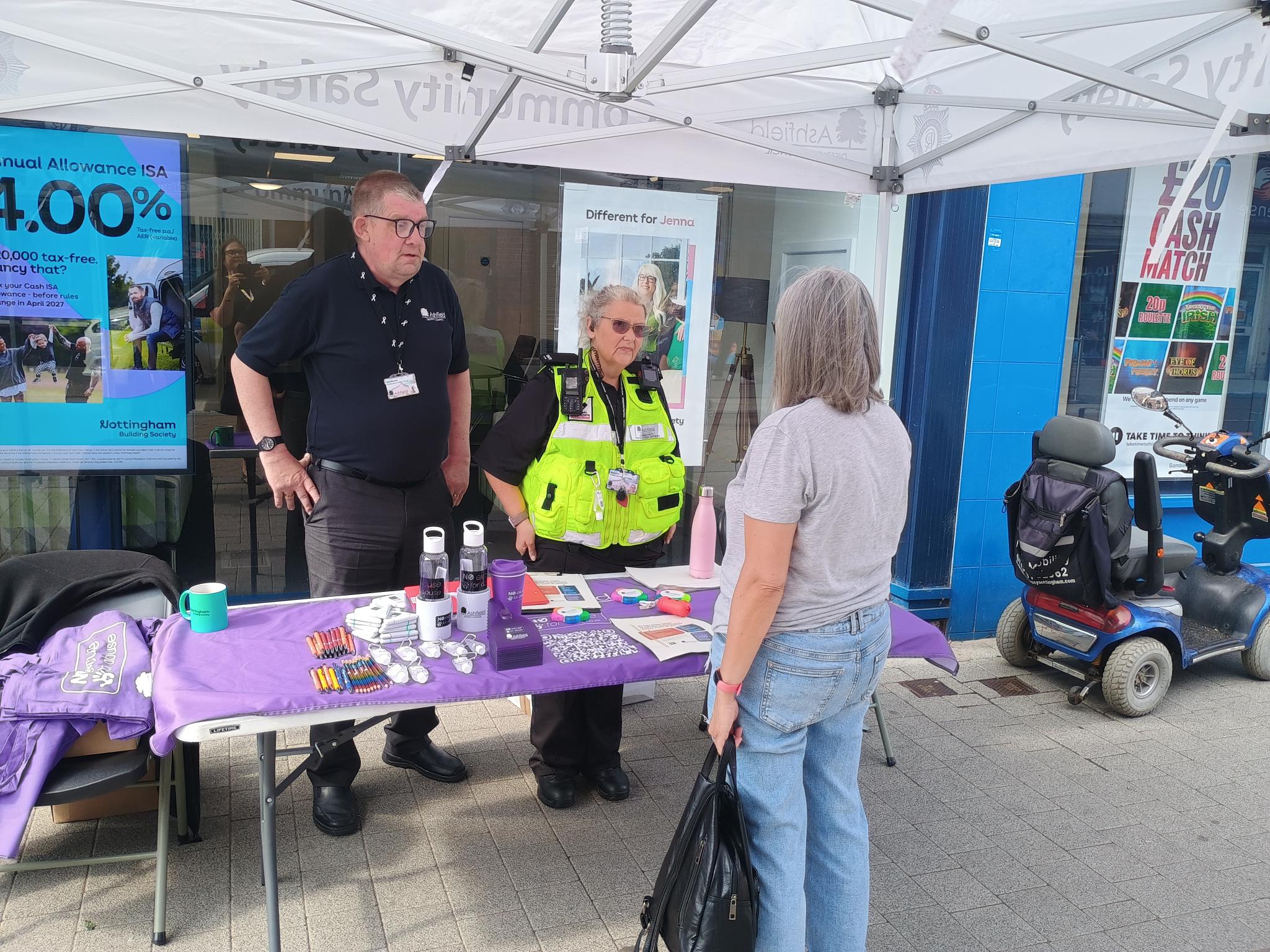 A man and a woman talking to a resident on Hucknall High Street 