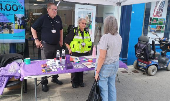 A man and a woman talking to a resident on Hucknall High Street 