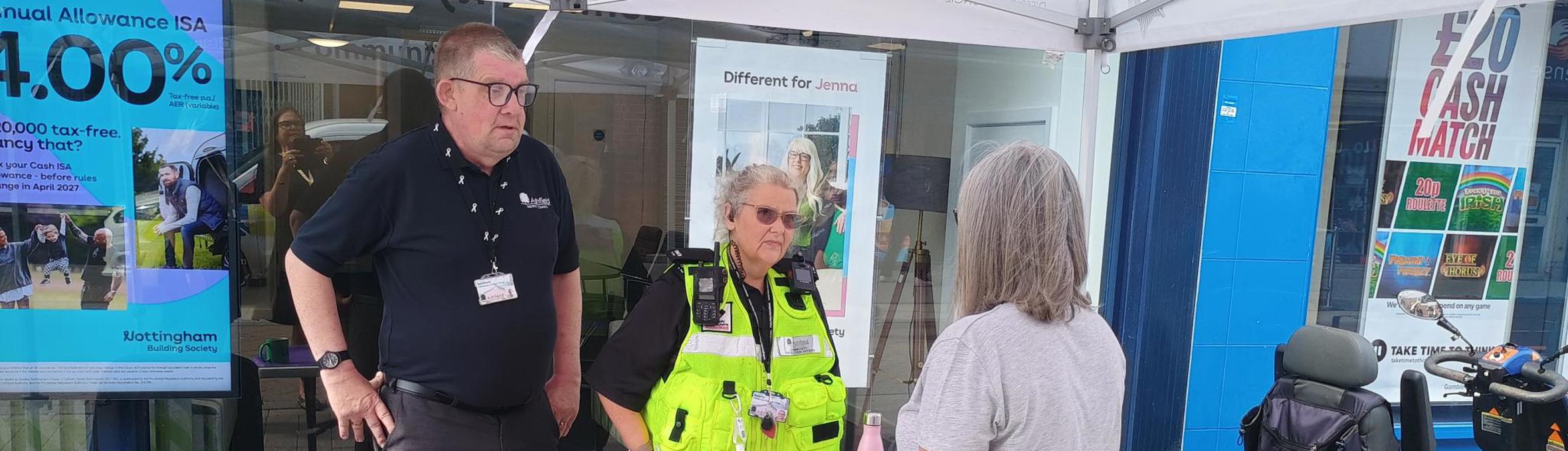 A man and a woman talking to a resident on Hucknall High Street 