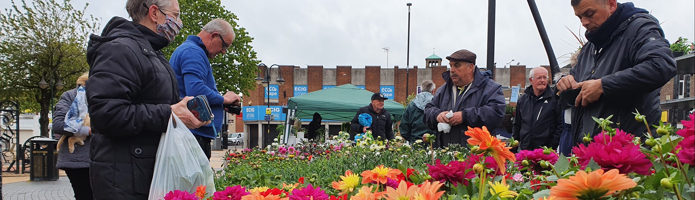people look at a colourful display of dahlias on Portland Square in Sutton 