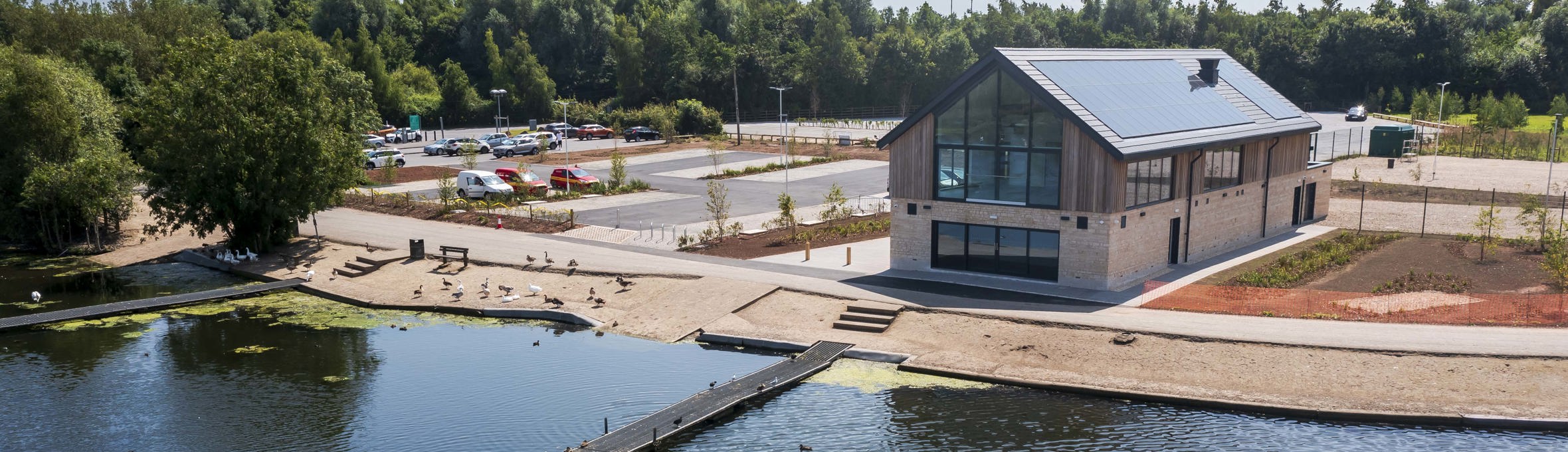 A stone and timber building with large windows overlooking Kings Mill Reservoir 